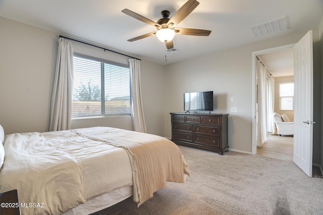 bedroom with visible vents, ceiling fan, light carpet, and baseboards