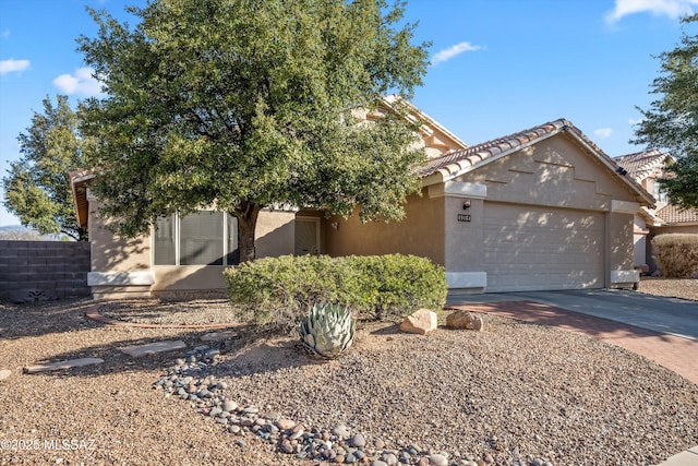 obstructed view of property featuring a garage, a tile roof, concrete driveway, and stucco siding