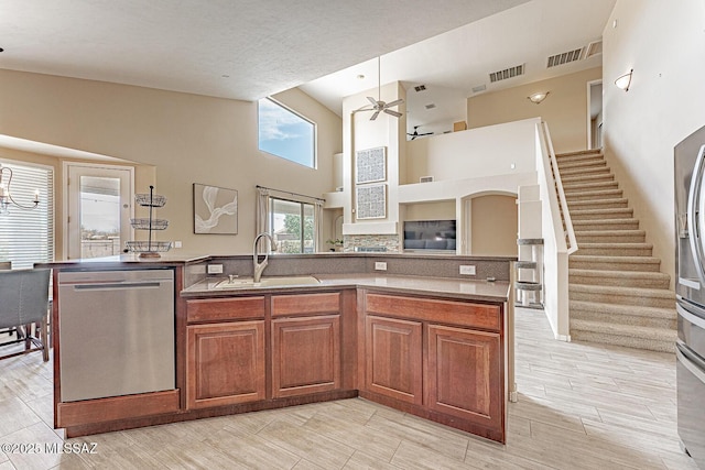 kitchen featuring a sink, visible vents, brown cabinetry, and dishwasher