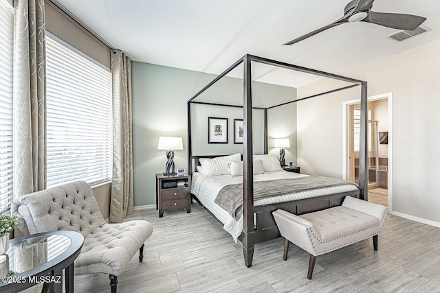 bedroom featuring wood finish floors, visible vents, ceiling fan, and ensuite bathroom