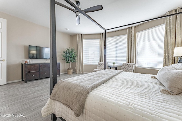 bedroom with a ceiling fan, baseboards, and light wood finished floors