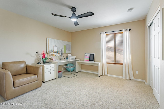 living area featuring carpet, baseboards, and a ceiling fan