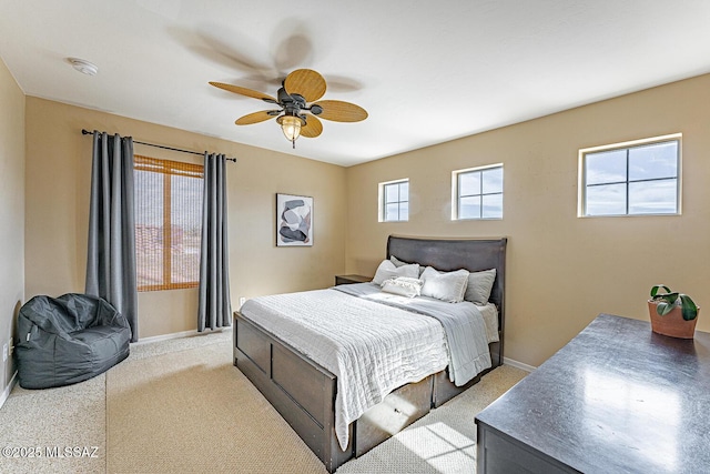 bedroom featuring baseboards, a ceiling fan, and light colored carpet