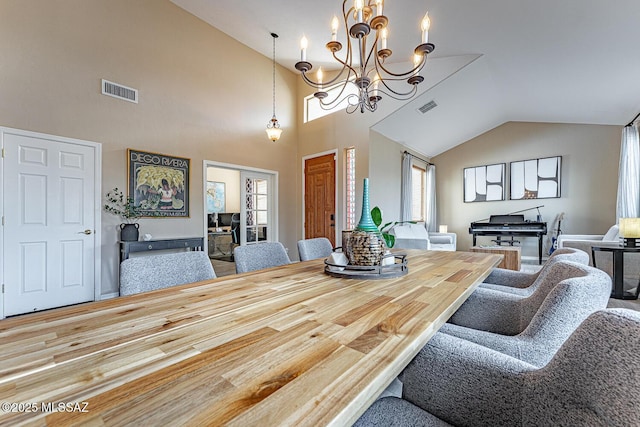 dining area featuring visible vents, vaulted ceiling, and a notable chandelier