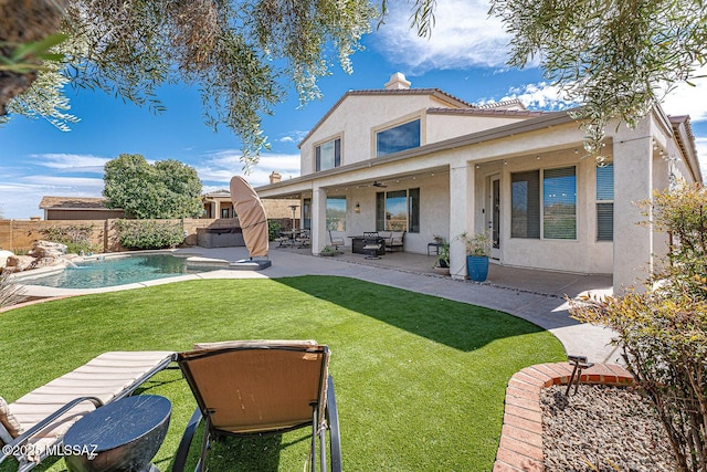 rear view of property with a patio, a fenced backyard, a chimney, a yard, and stucco siding