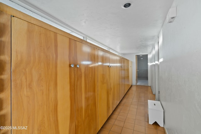 hall featuring light tile patterned floors