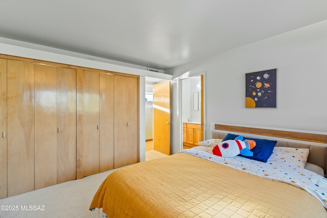 bedroom featuring connected bathroom, visible vents, and a closet