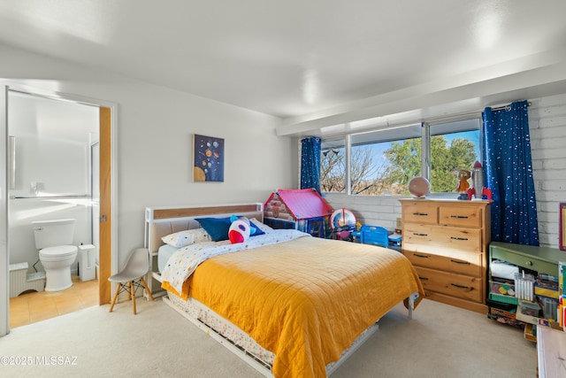 bedroom featuring light carpet and connected bathroom