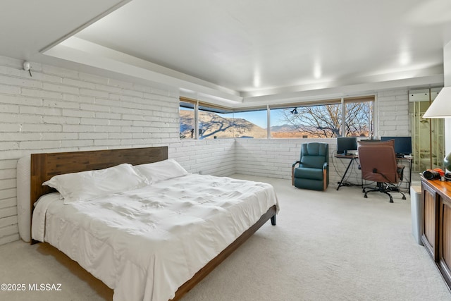 bedroom with light carpet and brick wall