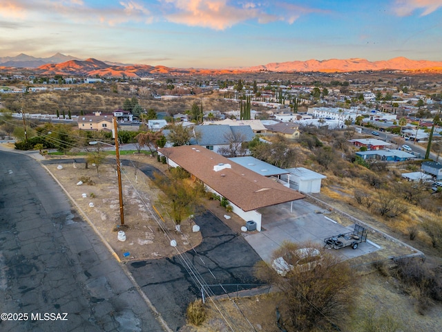 aerial view at dusk featuring a residential view and a mountain view