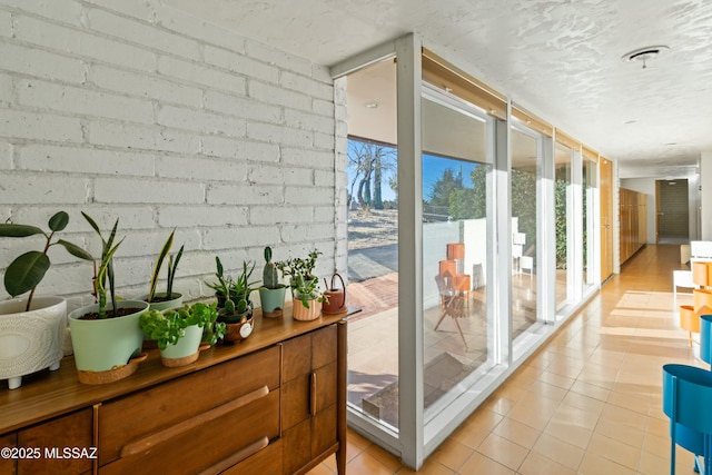 entryway with expansive windows and light tile patterned floors