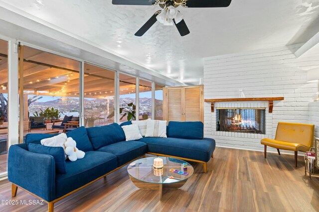 living area featuring a fireplace, wood finished floors, and a mountain view