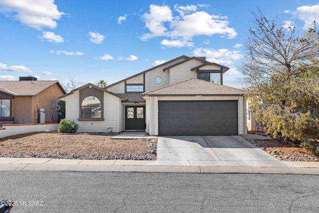 view of front of property with a garage, concrete driveway, and roof with shingles