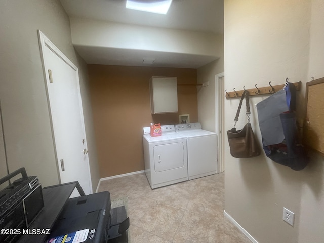 washroom featuring cabinet space, baseboards, and separate washer and dryer