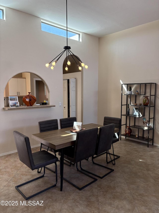 dining area with a high ceiling and baseboards