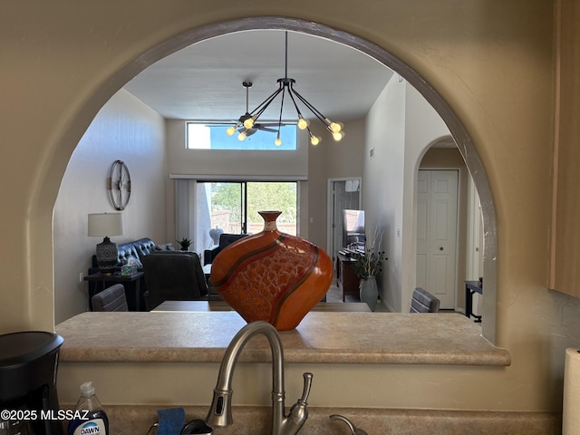 interior space featuring arched walkways, hanging light fixtures, open floor plan, and an inviting chandelier