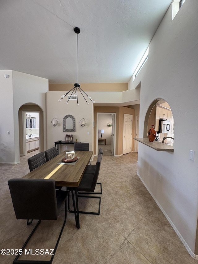 dining room with baseboards and arched walkways