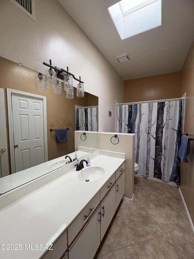 full bathroom with a skylight, visible vents, a shower with shower curtain, toilet, and vanity