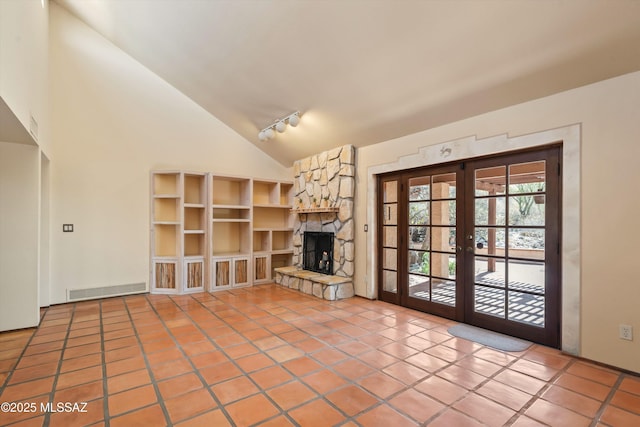 unfurnished living room with high vaulted ceiling, a stone fireplace, light tile patterned flooring, visible vents, and french doors