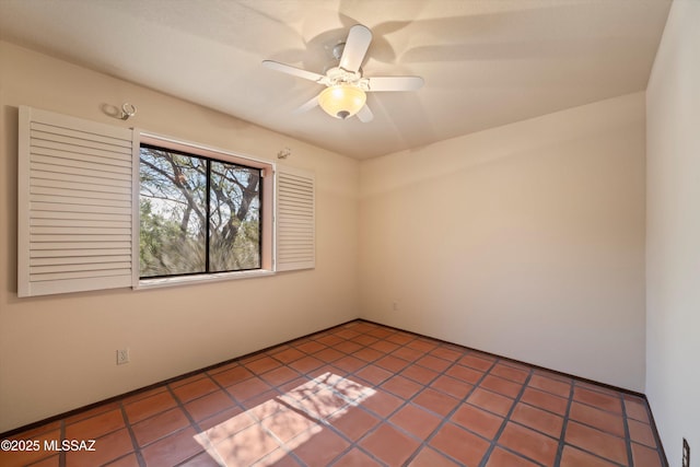 tiled empty room with a ceiling fan