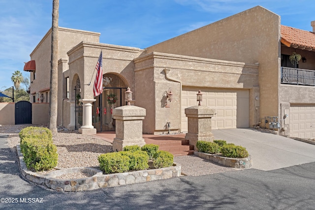 view of front facade featuring a gate, concrete driveway, and stucco siding