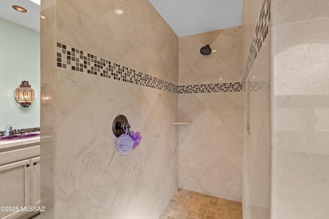 bathroom featuring a tile shower and vanity