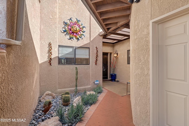 doorway to property featuring stucco siding