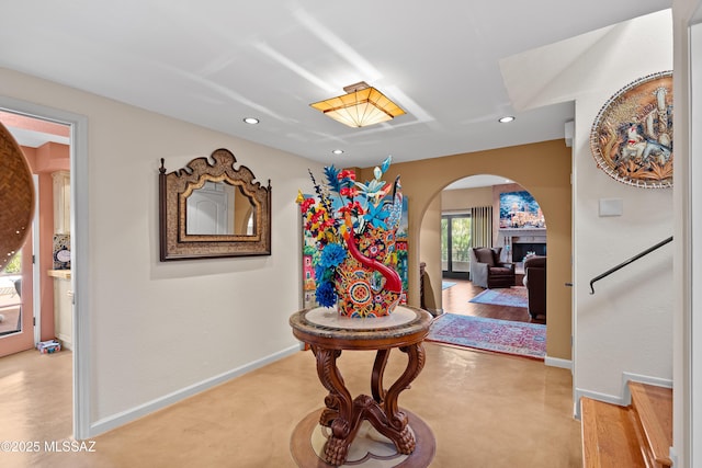 hall featuring arched walkways, recessed lighting, and baseboards