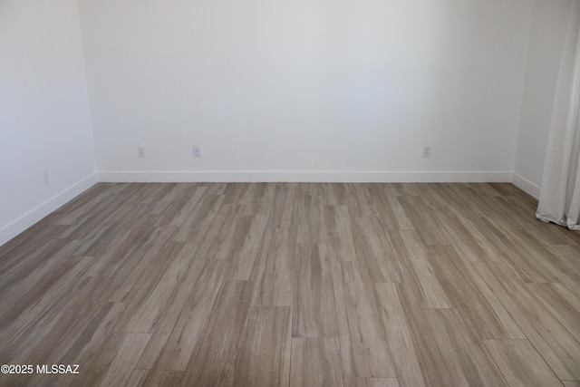 unfurnished room with light wood-style flooring and baseboards