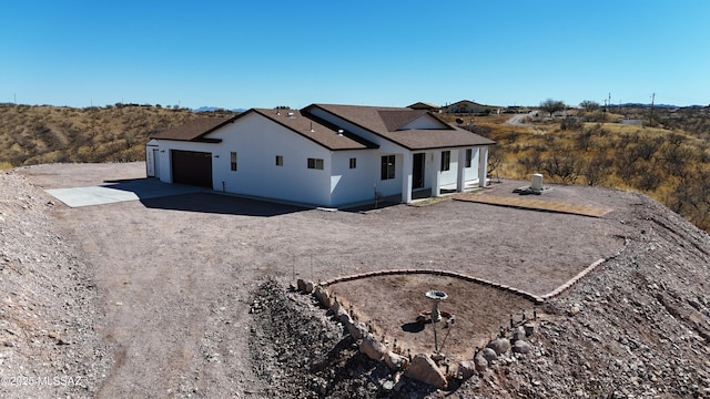 view of front of home with a garage, concrete driveway, and stucco siding