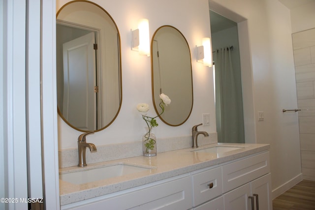 bathroom featuring double vanity, a sink, and wood finished floors