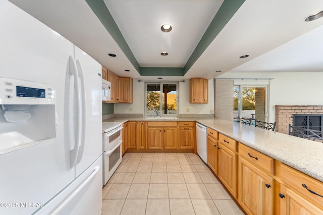 kitchen with white appliances, light tile patterned floors, a raised ceiling, a peninsula, and light countertops