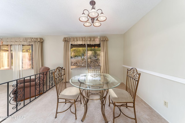 dining room featuring light carpet, a chandelier, and a healthy amount of sunlight