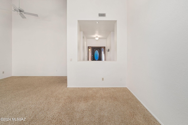 carpeted empty room with visible vents and a ceiling fan