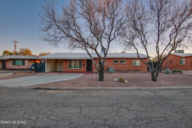 ranch-style house with concrete driveway and brick siding