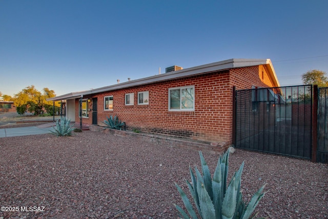 view of front of home featuring brick siding and fence