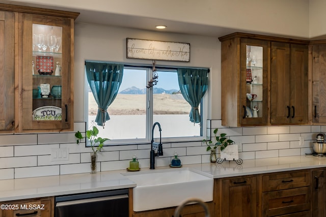 16 Star View Dr, Sonoita, AZ 85637 - kitchen with a sink, dishwasher, decorative backsplash, glass insert cabinets, and light countertops