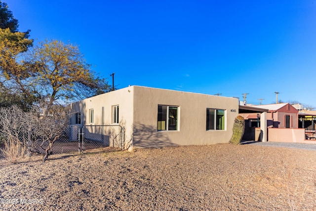 exterior space with fence, a gate, and stucco siding