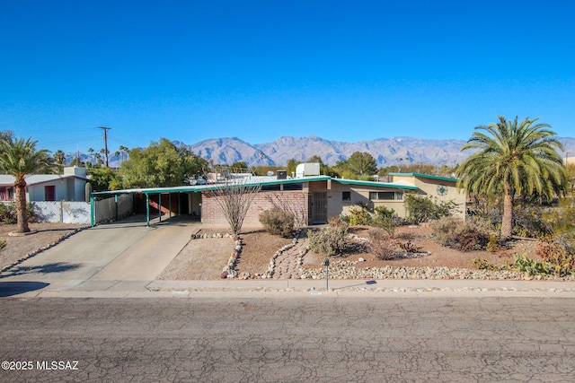 view of front of house featuring an attached carport, a mountain view, and driveway