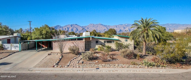 view of front facade featuring driveway, a mountain view, and a carport