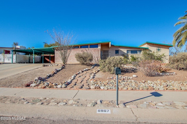 view of front of house featuring an attached carport, driveway, and stucco siding