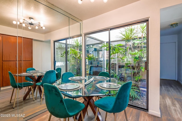 dining space with a notable chandelier and wood finished floors