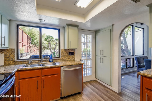 1310 N Dorado Way, Tucson, AZ 85715 - kitchen featuring stainless steel dishwasher, a sink, light wood finished floors, a textured ceiling, and decorative backsplash