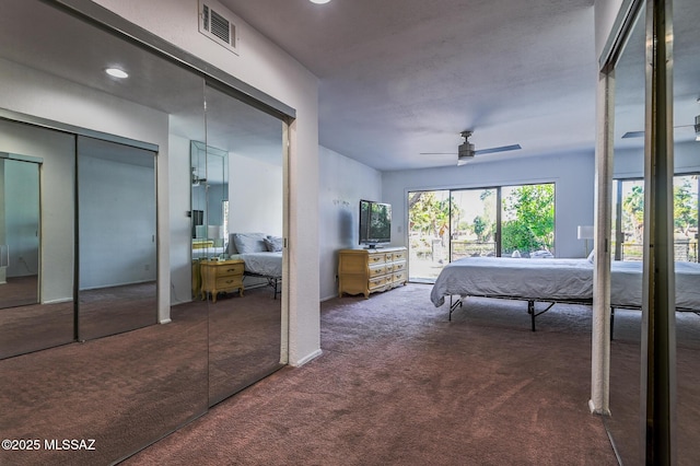 bedroom with access to exterior, multiple closets, dark colored carpet, visible vents, and ceiling fan