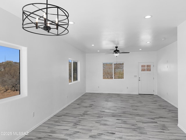 unfurnished living room featuring light wood-style floors, a wealth of natural light, baseboards, and recessed lighting