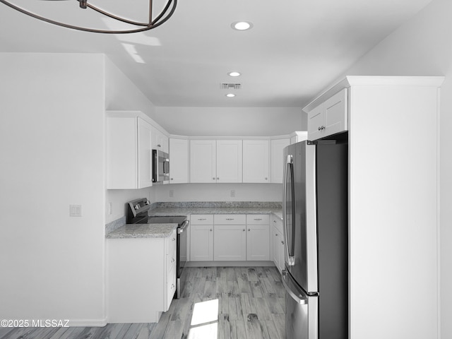 kitchen featuring recessed lighting, stainless steel appliances, visible vents, white cabinets, and light wood finished floors