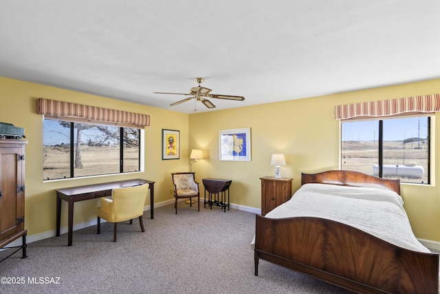 carpeted bedroom with ceiling fan, multiple windows, and baseboards