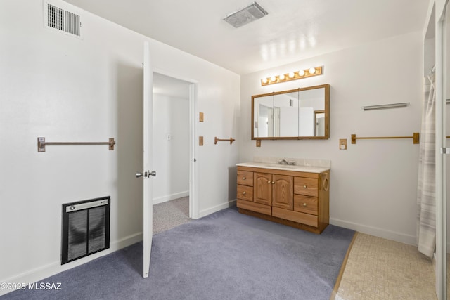 bathroom featuring heating unit, carpet floors, visible vents, and vanity