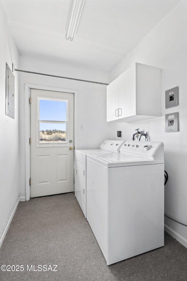 laundry room featuring cabinet space, electric panel, baseboards, and washer and clothes dryer