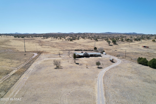 drone / aerial view featuring view of desert, a rural view, and a mountain view